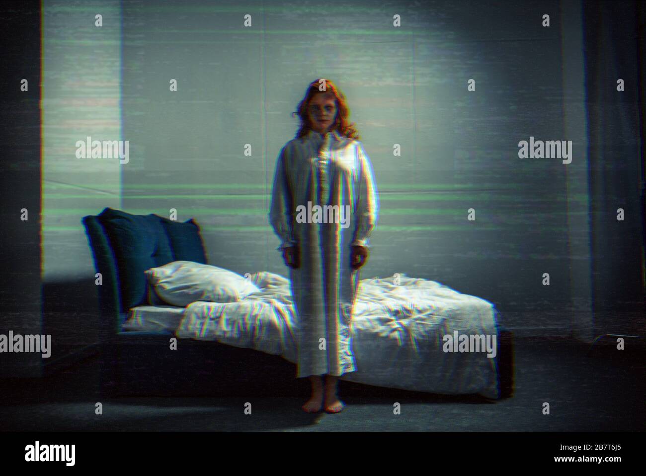 creepy demoniacal girl in nightgown standing in bedroom with tv noise Stock Photo
