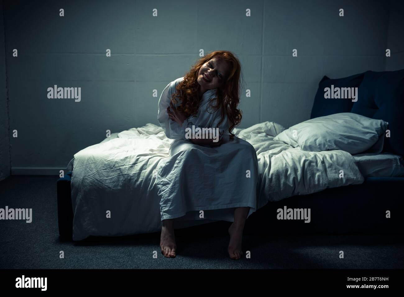 crazy demoniacal smiling woman in nightgown sitting on bed Stock Photo ...