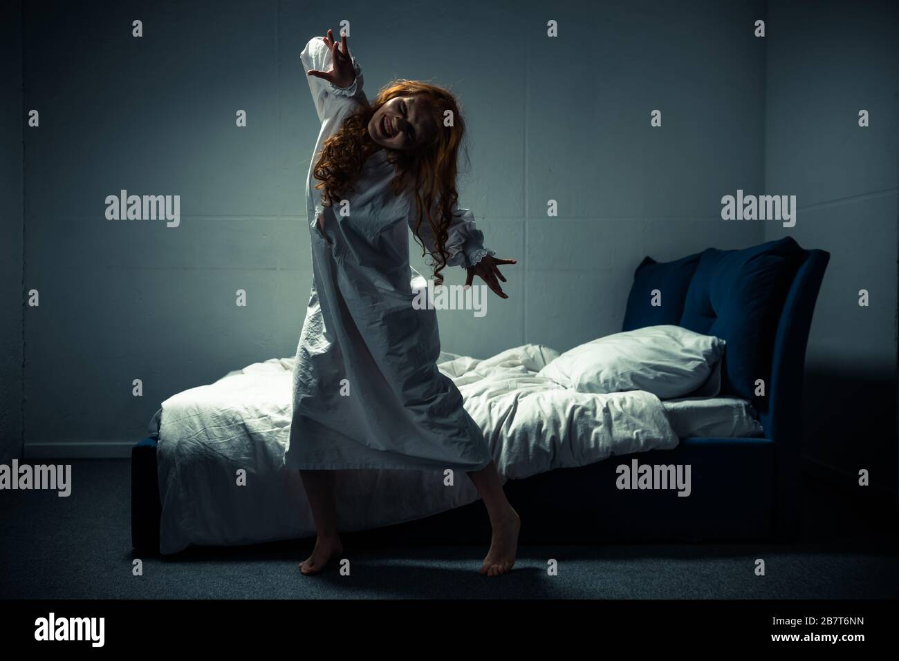 smiling obsessed woman in nightgown standing near bed Stock Photo - Alamy