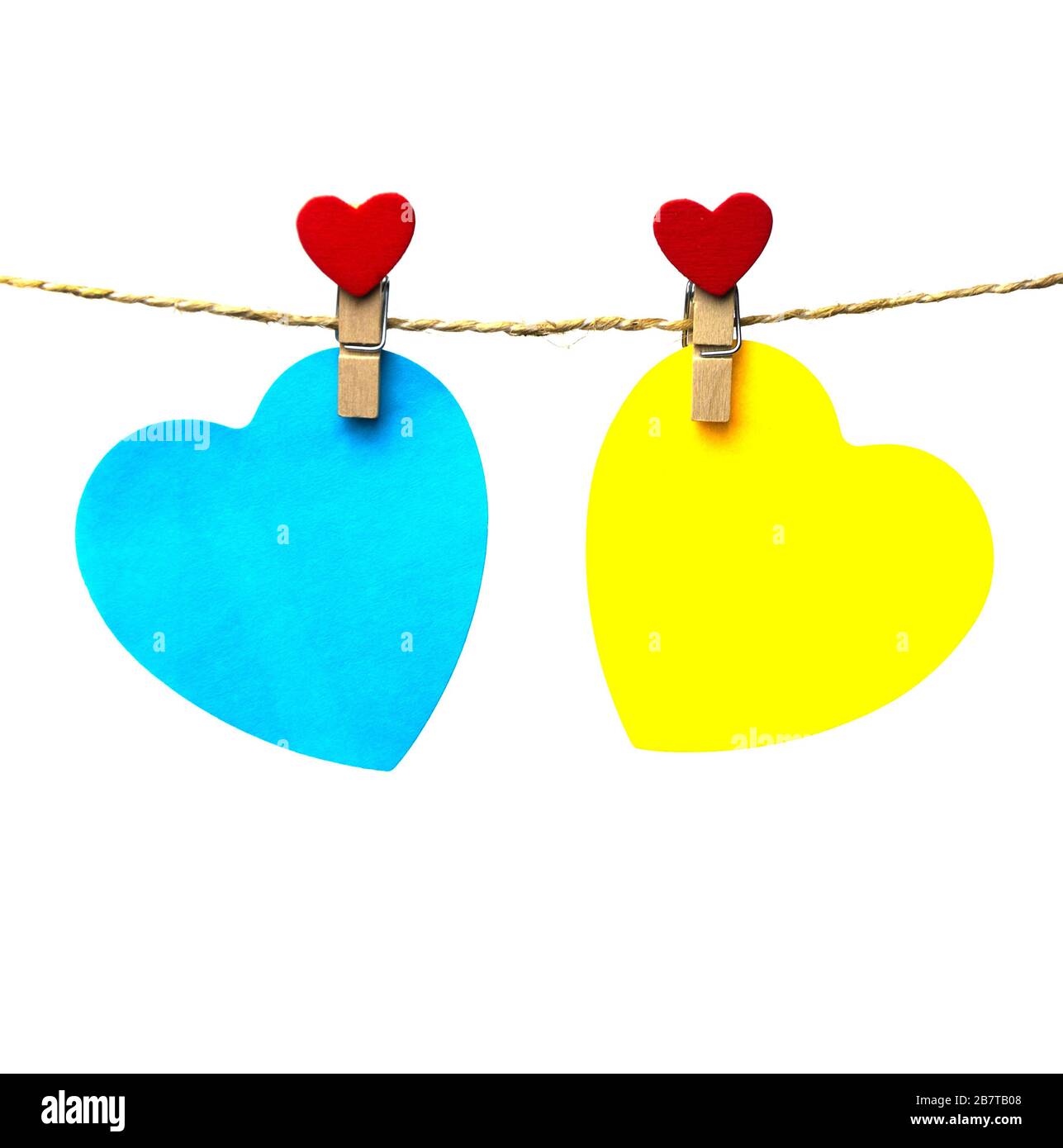 two blue and yellow hearts hanging on a rope attached with trailers 2 Stock Photo
