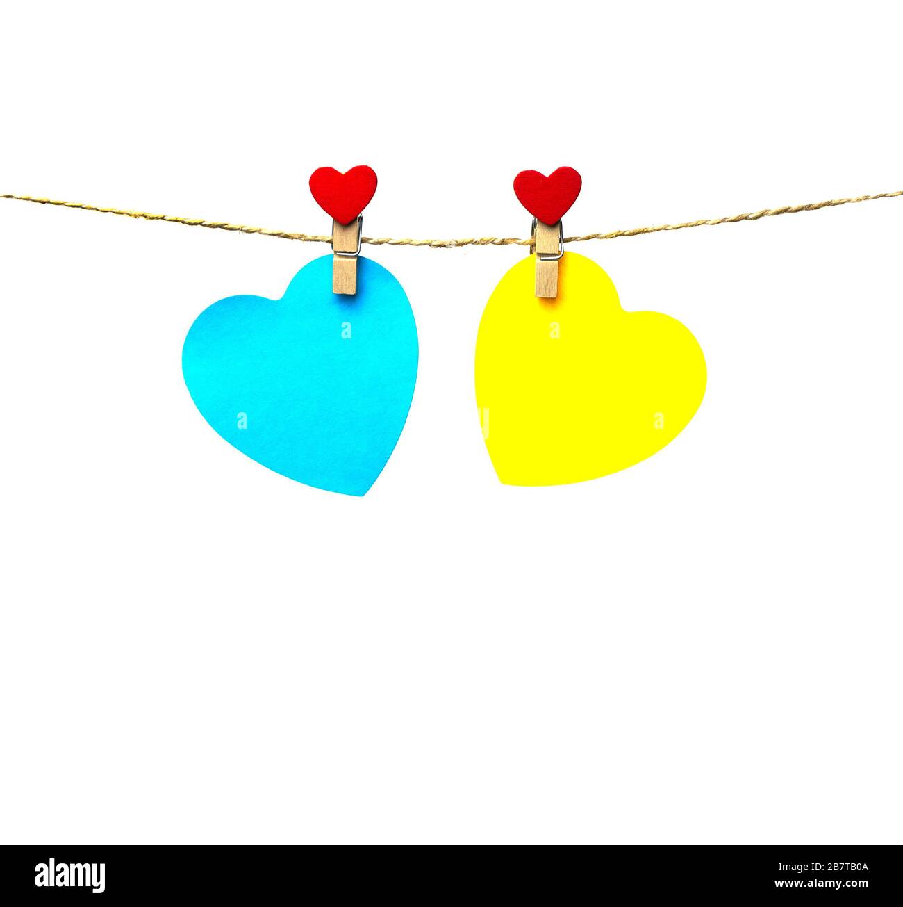 two blue and yellow hearts hanging on a rope attached with trailers Stock Photo