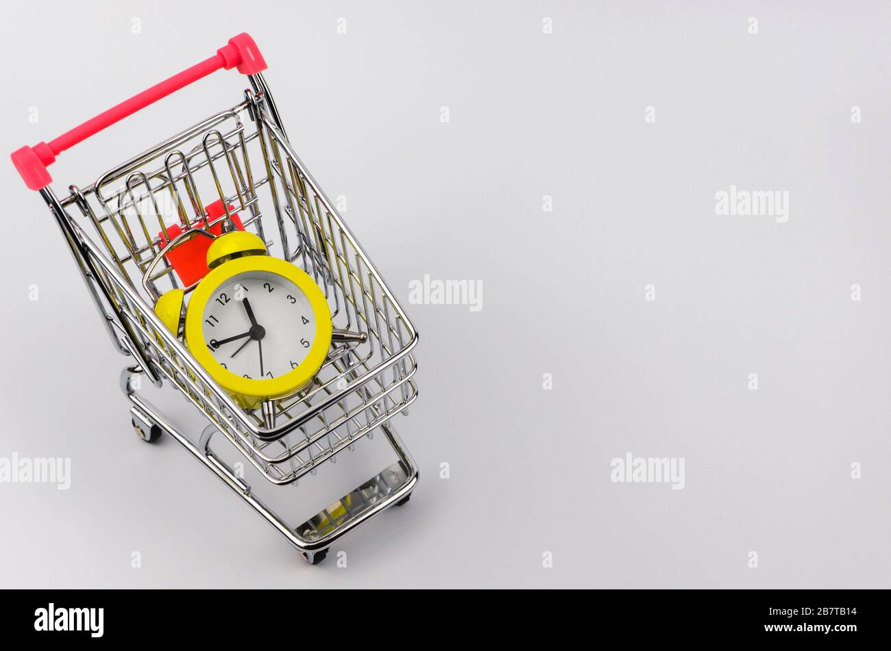 Yellow alarm clock in a shopping trolley 3 Stock Photo