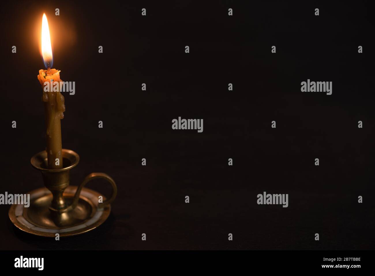 church candle in candlestick burning in dark Stock Photo Alamy