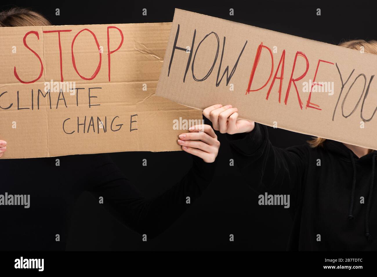 Cropped view of blondes with placards with stop climate change and how dare you lettering isolated on black, global warming concept Stock Photo