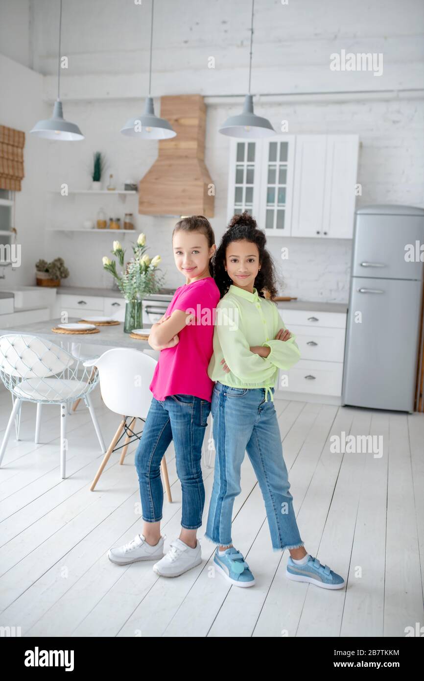 Two friends standing in the kitchen looking joyful Stock Photo - Alamy