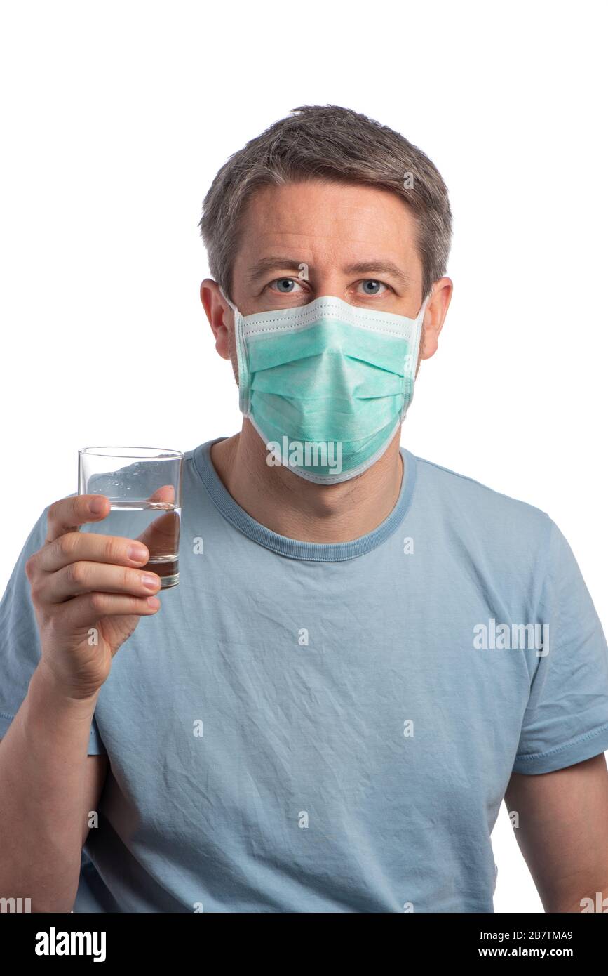 Caucasian man wearing a protection mask with a glass of water on a white background Stock Photo