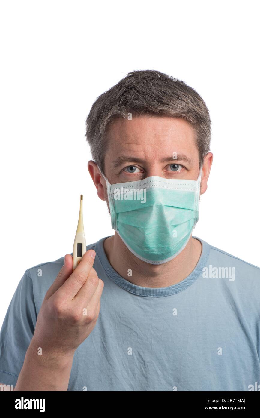 Caucasian man wearing a protection mask with a thermometer on a white background Stock Photo