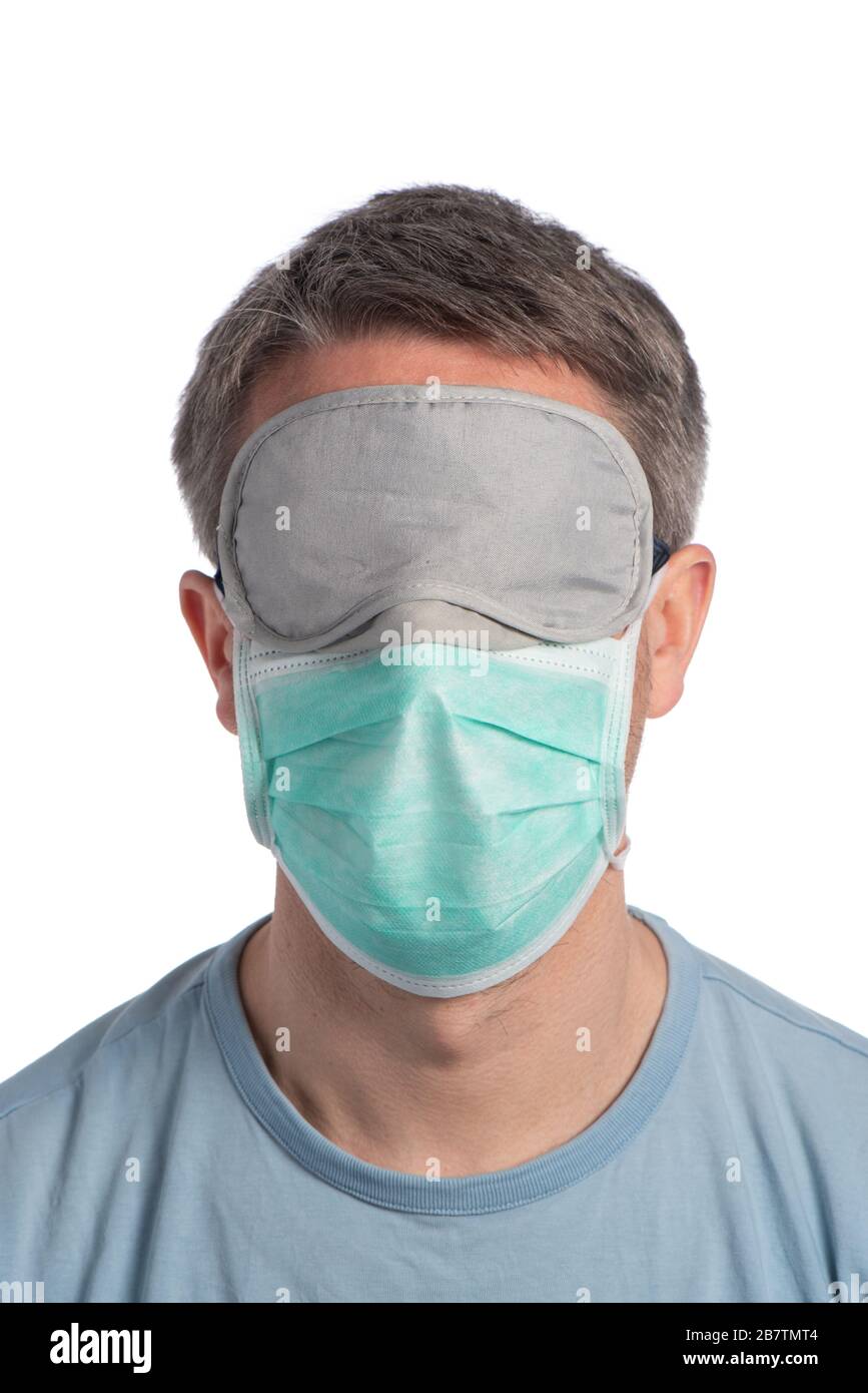 Caucasian man wearing a protection mask and a sleeping mask on a white background Stock Photo