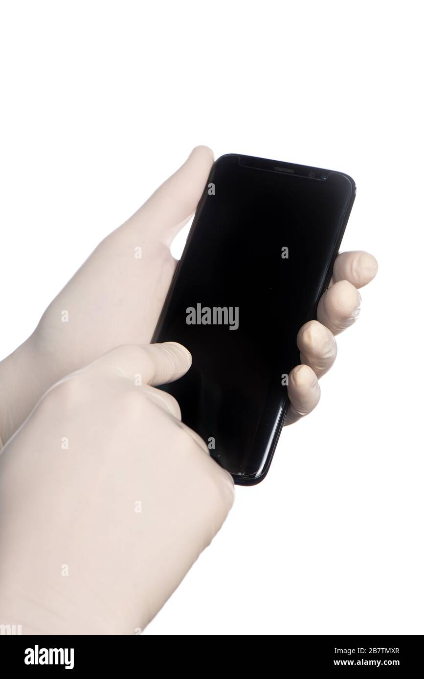 Using a cell phone with white protective gloves Stock Photo