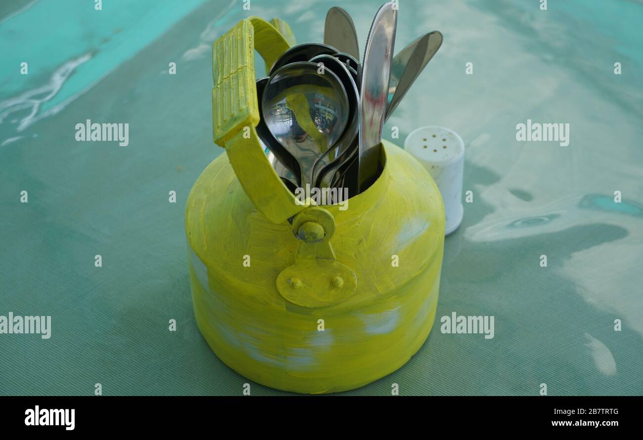 Kitchen utensils and cutlery in old fashioned green vintage teapot in