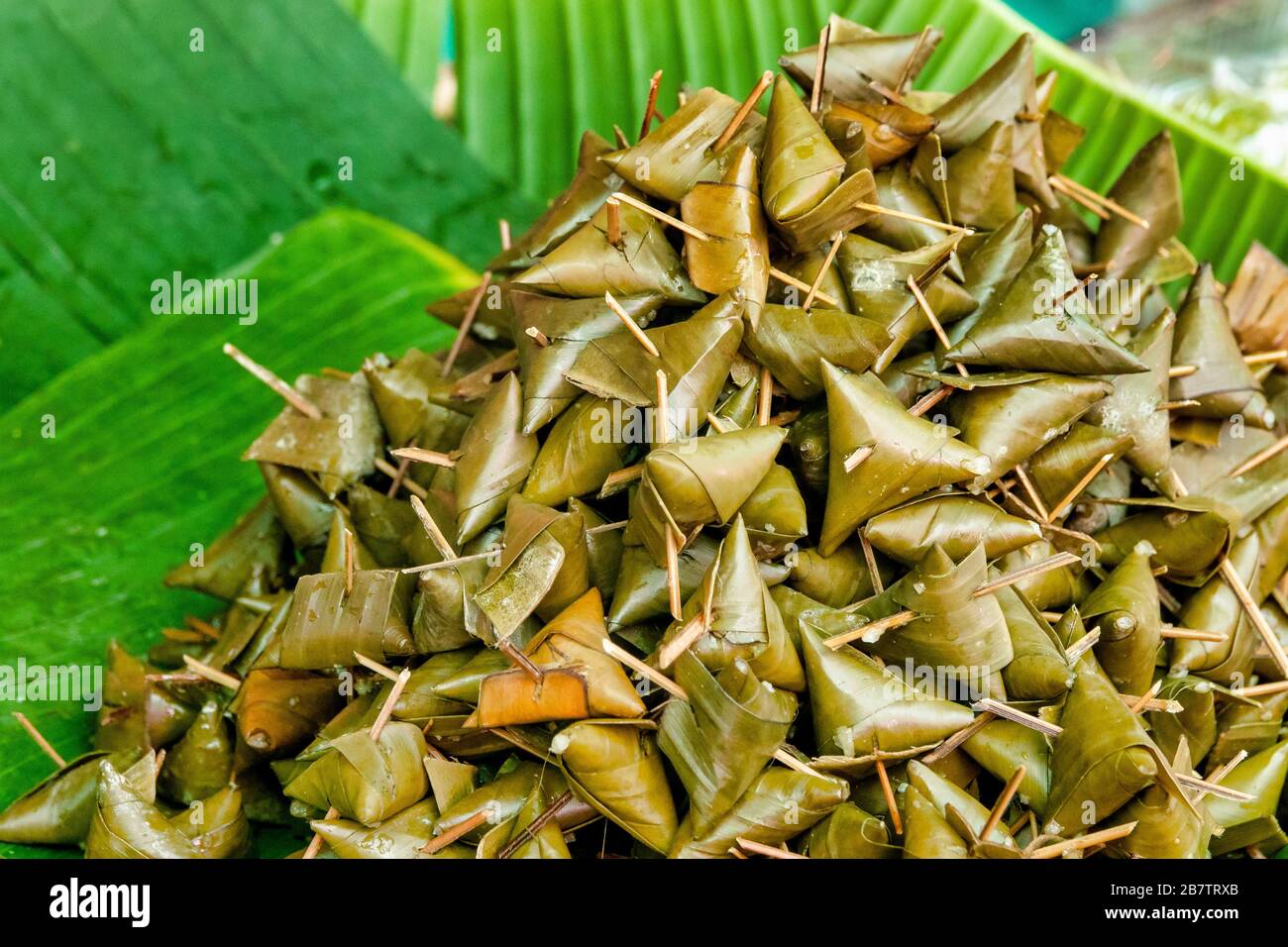 Khao tom, traditional thai and laotian dessert consisting of seasoned steamed sticky rice wrapped in banana leaves Stock Photo