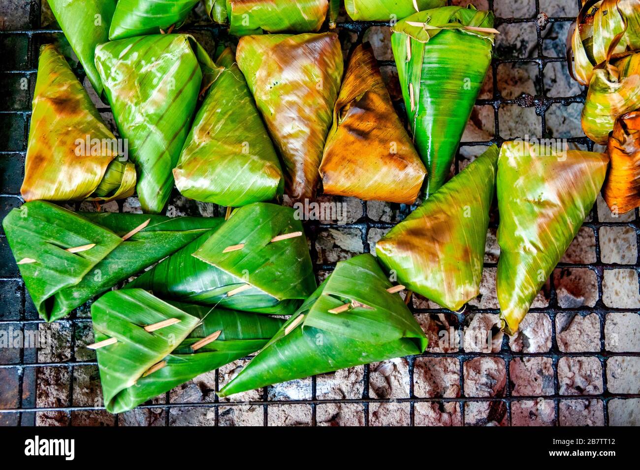 Khao tom, traditional thai and laotian dessert consisting of seasoned steamed sticky rice wrapped in banana leaves Stock Photo