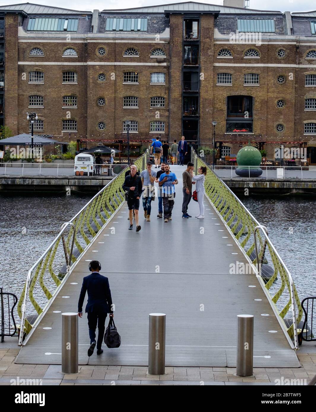 People crossing the North Dock Footbridge from Canary Wharf to West India Quay.  London, UK. Stock Photo