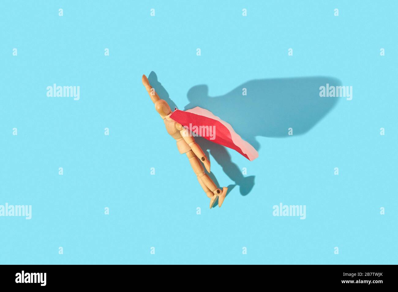 Movable human miniature model in red cape as a superman flies up. Stock Photo