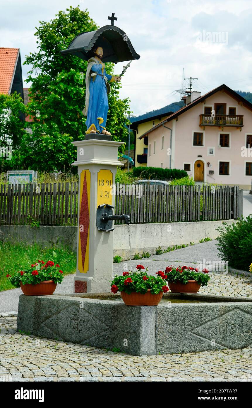 Austria, Tyrol, drinking water well with statue of christ Stock Photo