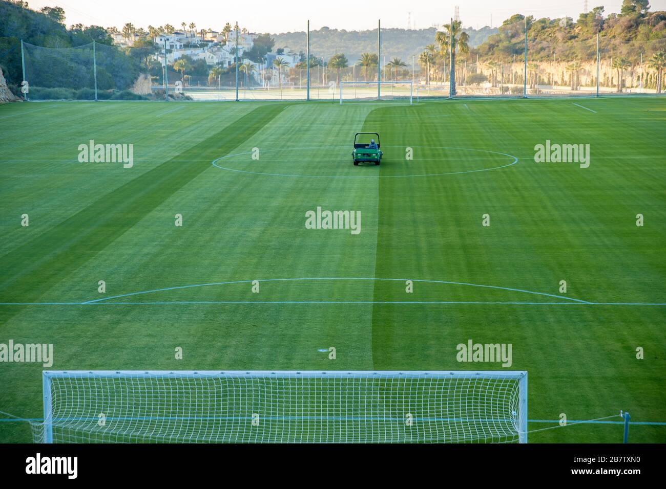 Maintaining a football field using a motorized lawn mower Stock Photo
