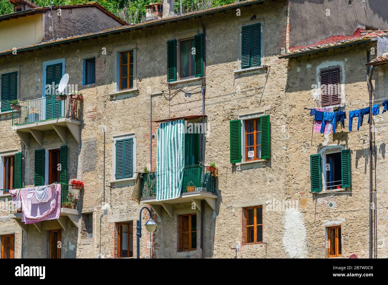 Colle di Val d'Elsa, Tuscany / Italy: Residential houses of the lower town with clothes drying in the sun on washing lines under the apartment windows Stock Photo