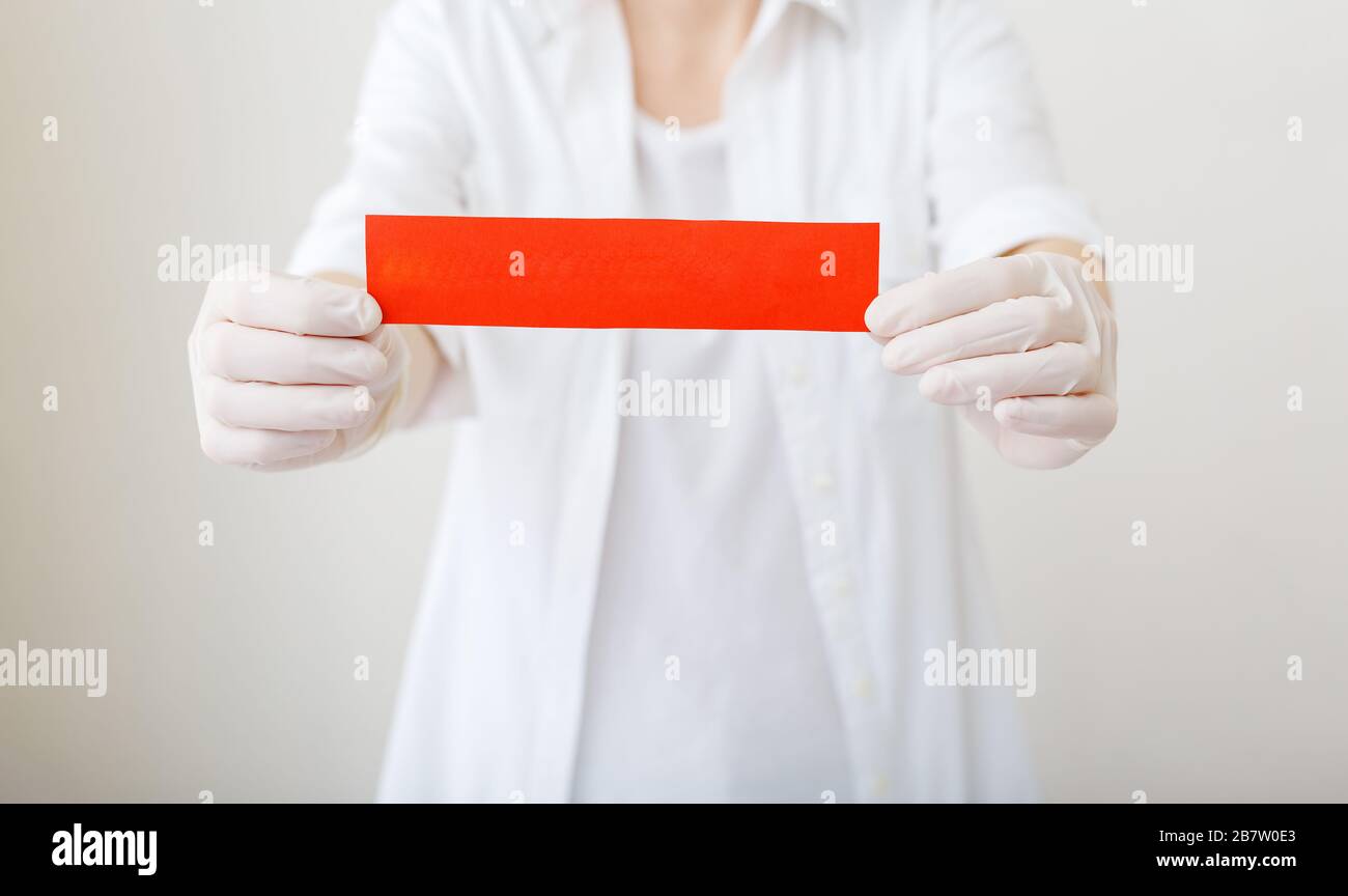 Doctor in a hospital holding red warning sign mock up for your text to stop virus, coronavirus or disease.Doctor hands in white coat, gloves. Concept Stock Photo