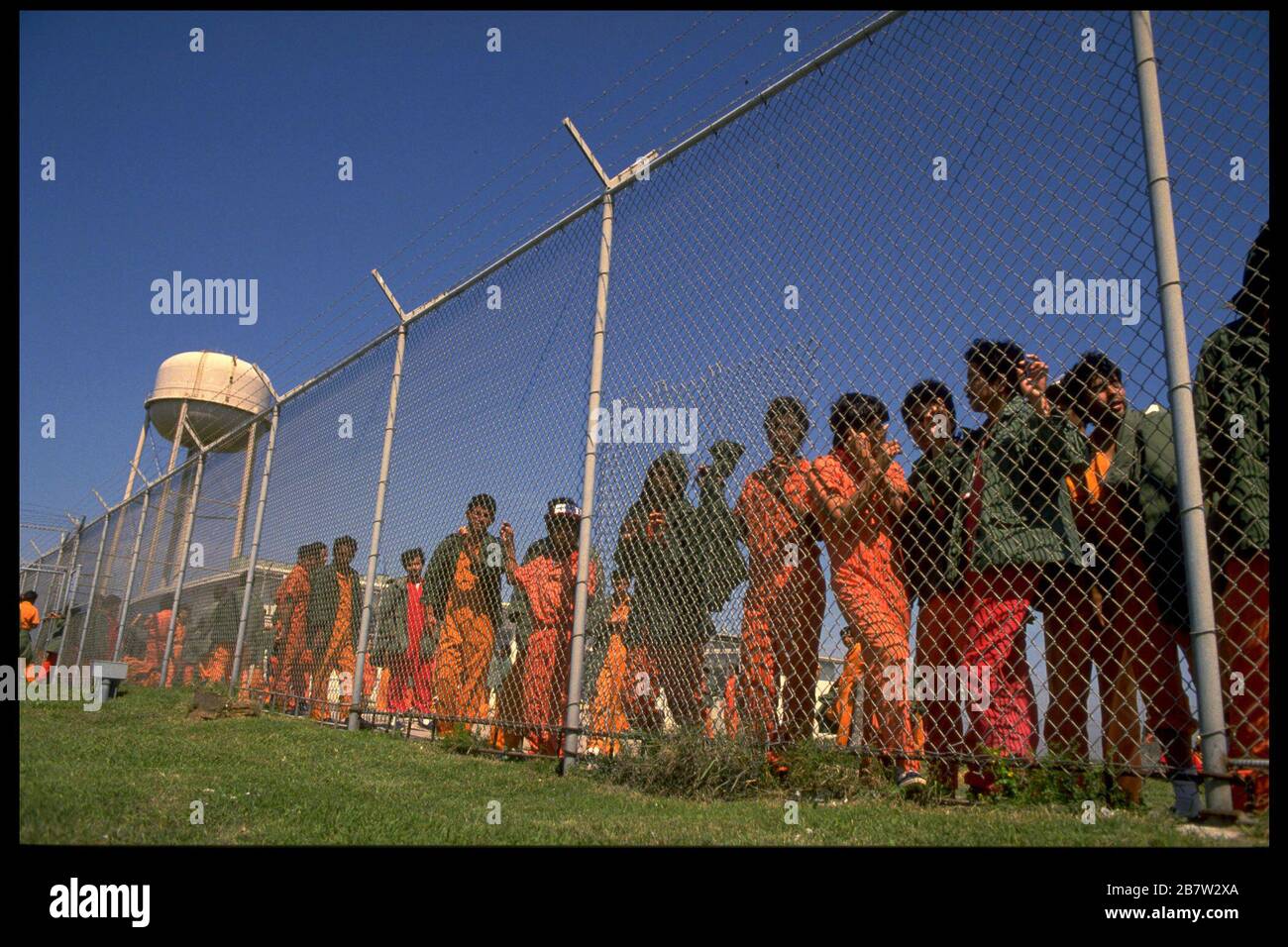 Dozens of detainees, caught by immigration officials crossing from Mexico into the United States illegally, crowd against fence at Immigration and Naturalization Service lockup in South Texas.    ©Bob Daemmrich Stock Photo