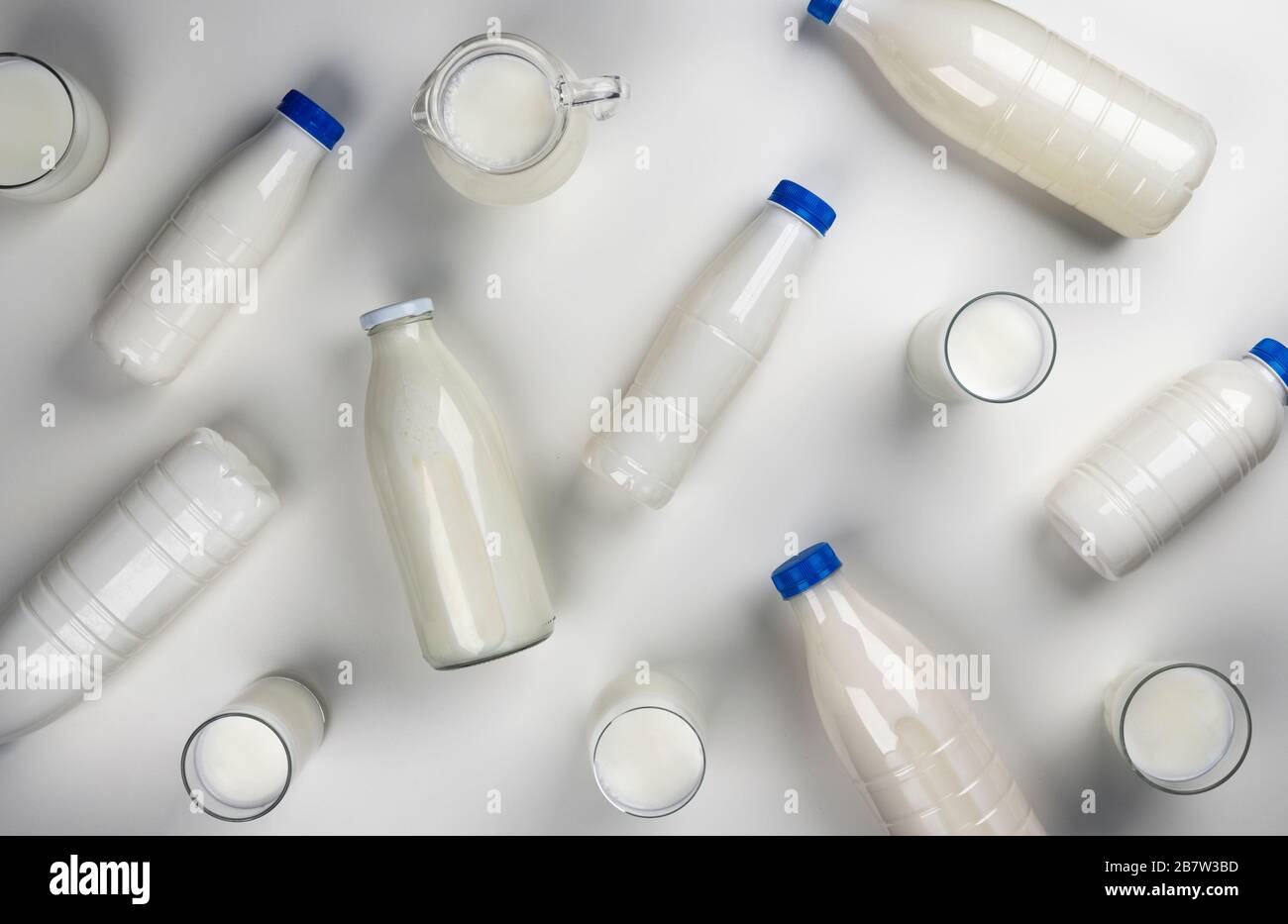 Dairy products packaging, bottles and glasses with milk on white