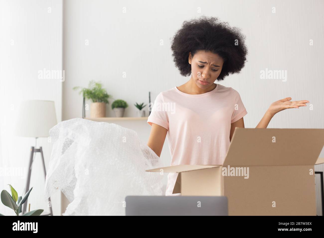 African american girl unhappy at delivery from online store Stock Photo