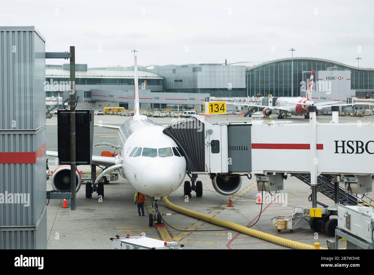 A colour landscape image showing a passenger jet at the gate at an airport. Stock Photo