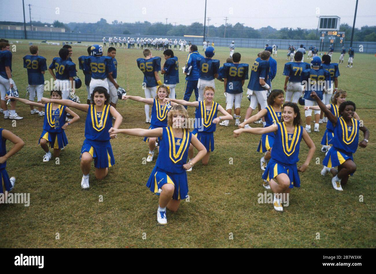 Austin Texas USA: Junior high school cheerleaders perform routine on sidelines of football game. ©Bob Daemmrich Stock Photo