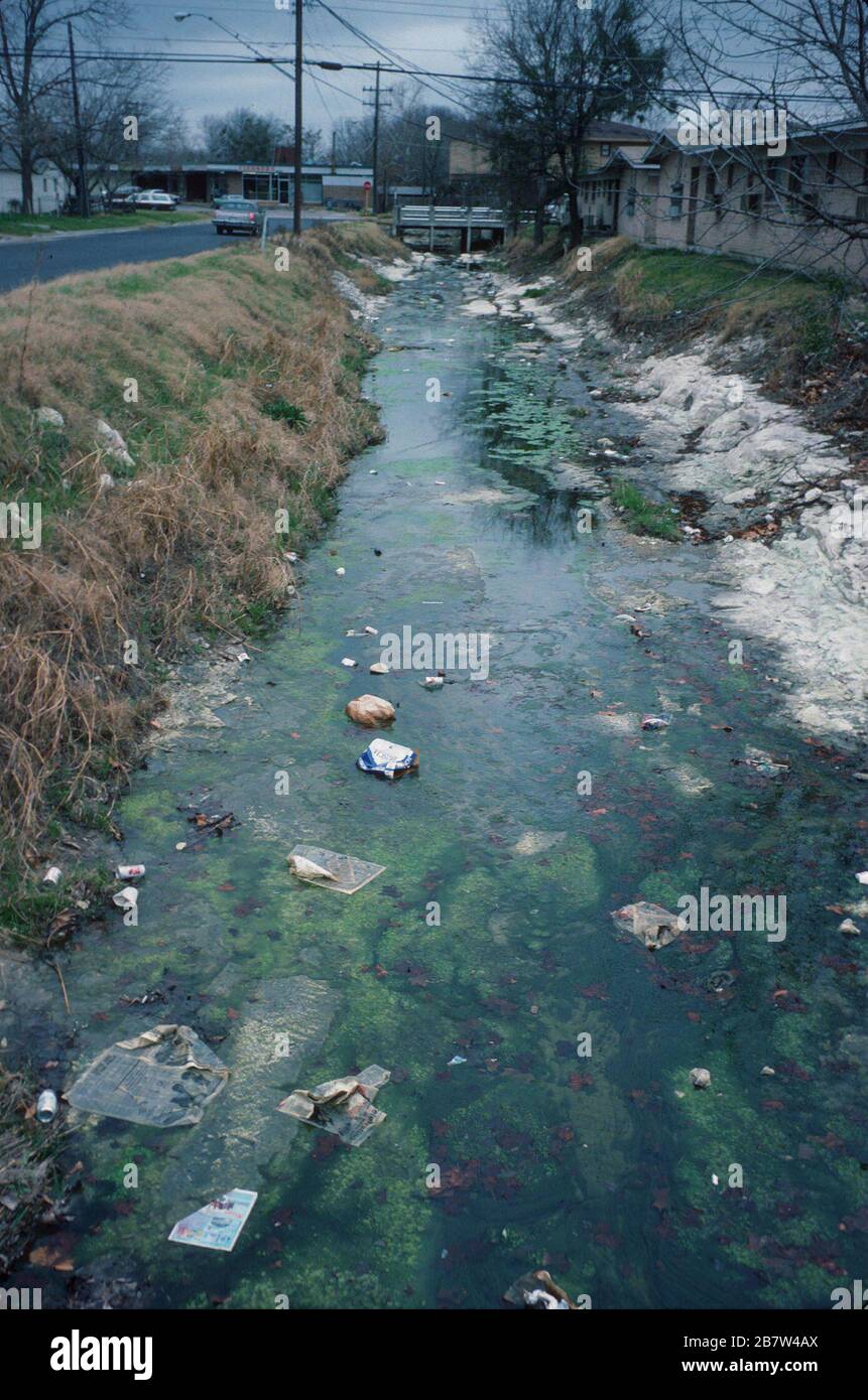 Austin Texas USA: Trash litters drainage ditch in residential neighborhood.  ©Bob Daemmrich Stock Photo