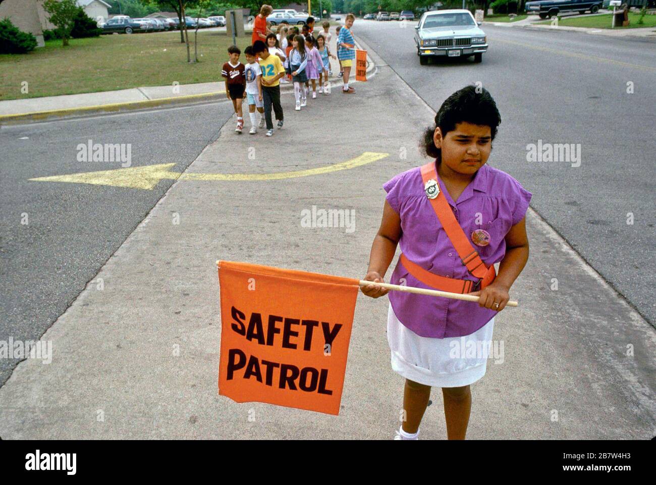 Austin Texas USA: Elementary school safety patrol member helps classmates to cross streets safely after school.  ©Bob Daemmrich Stock Photo
