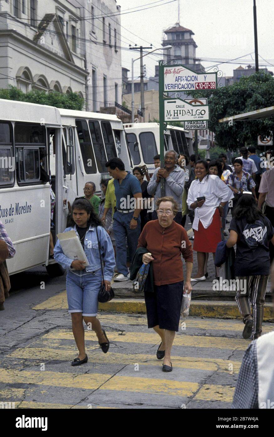 Morelos, Cuernavaca, Mexico:  Pedestrians crossing street at marked crosswalk near busy bus stop. ©Bob Daemmrich Stock Photo