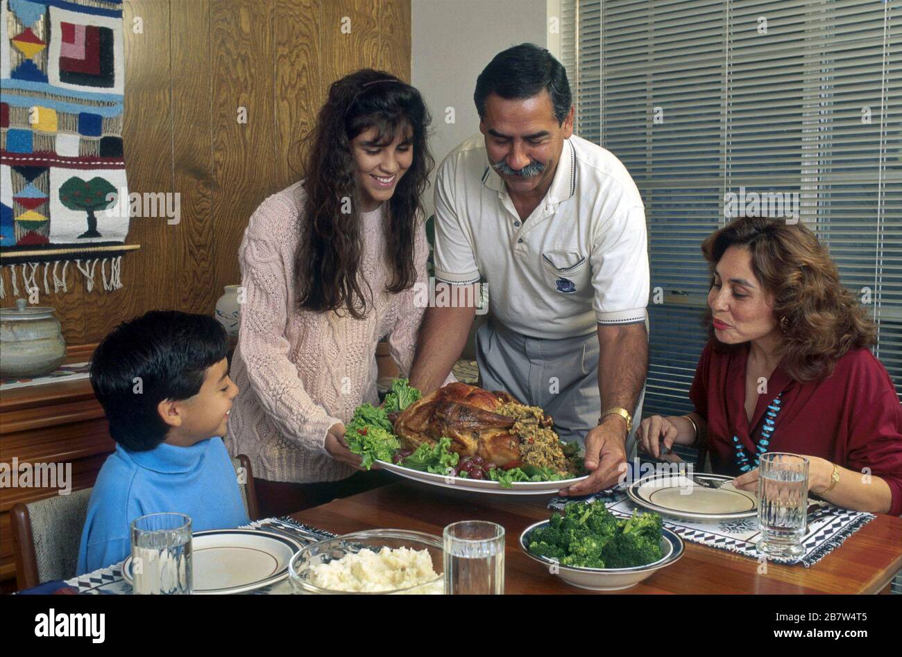 Father prepares to carve Thanksgiving turkey for family holiday meal. MR ©Bob Daemmrich Stock Photo
