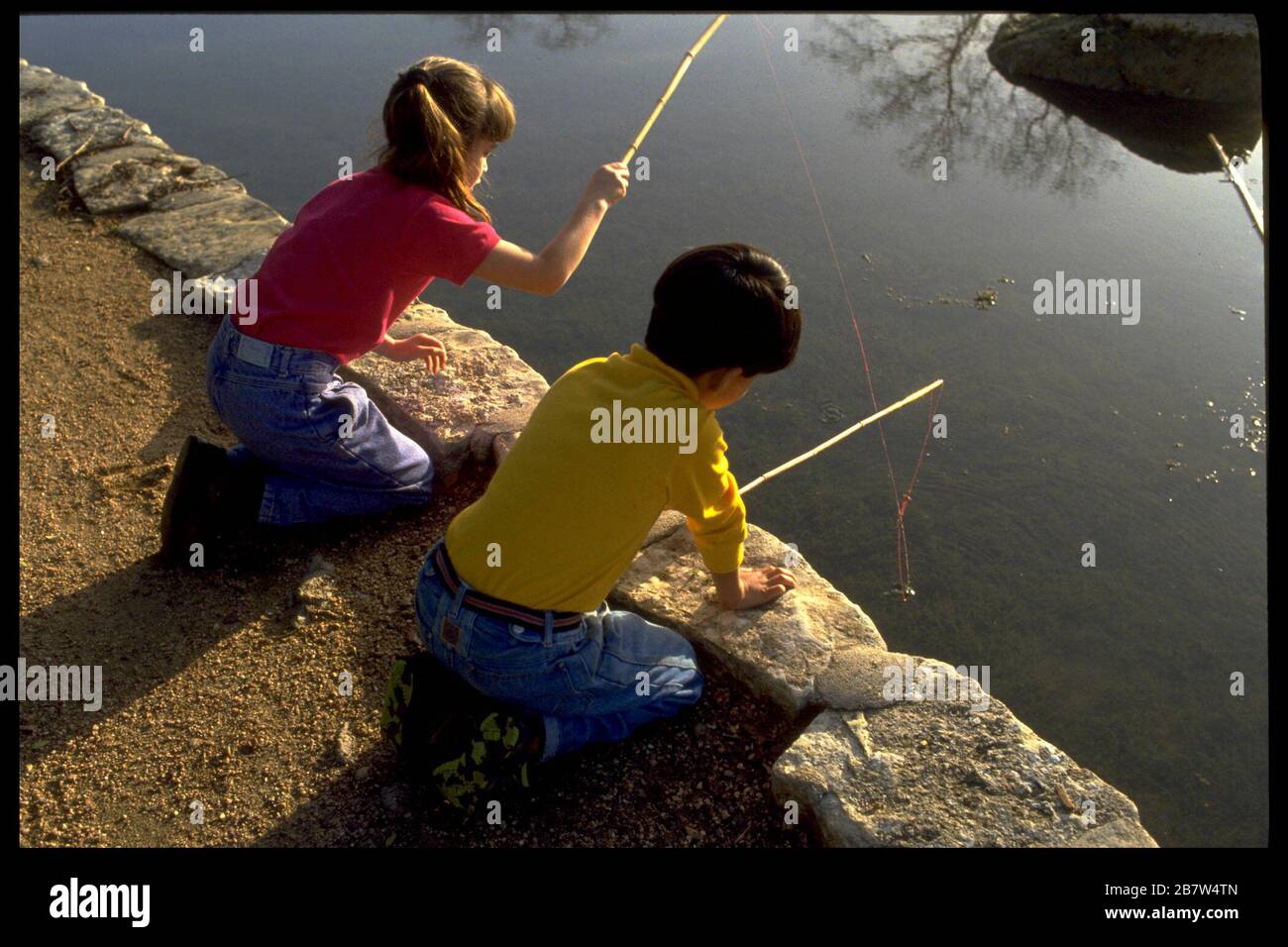 Austin Texas USA: Six-year-old boy and girl fishing in Barton Creek with bamboo fishing poles.   MR   ©Bob Daemmrich Stock Photo