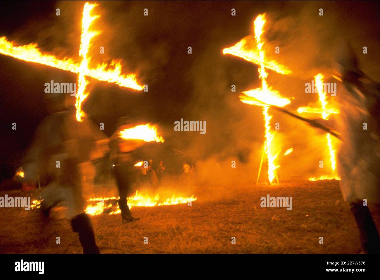 Bastrop Texas USA, Aug. 22, 1982: Southern hate group Ku Klux Klan (KKK) holds night-time rally and cross burning in a field. ©Bob Daemmrich Stock Photo