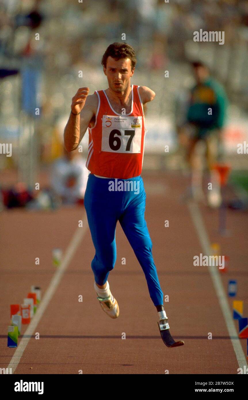 Barcelona Spain 1992: Male Paralympic long jumping competitor on runway towards long jump pit.  ©Bob Daemmrich. Stock Photo