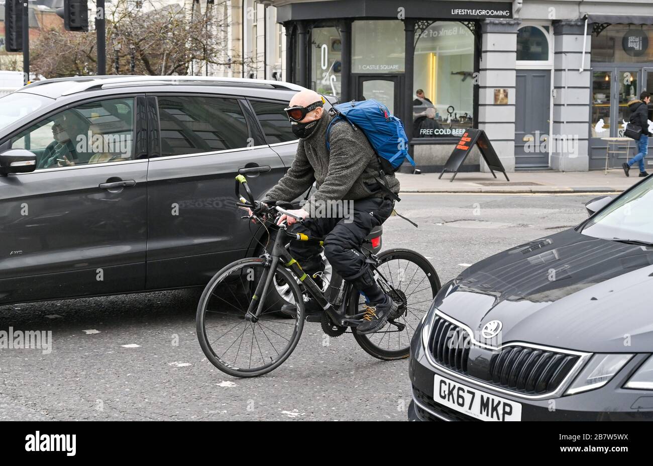 Brighton UK 18th March 2020 - A cyclist wearing a protective mask and goggles as the streets around Brighton are quieter than normal as people avoid coming into the city centre because of the Coronavirus COVID-19 pandemic crisis  . Credit: Simon Dack / Alamy Live News Stock Photo