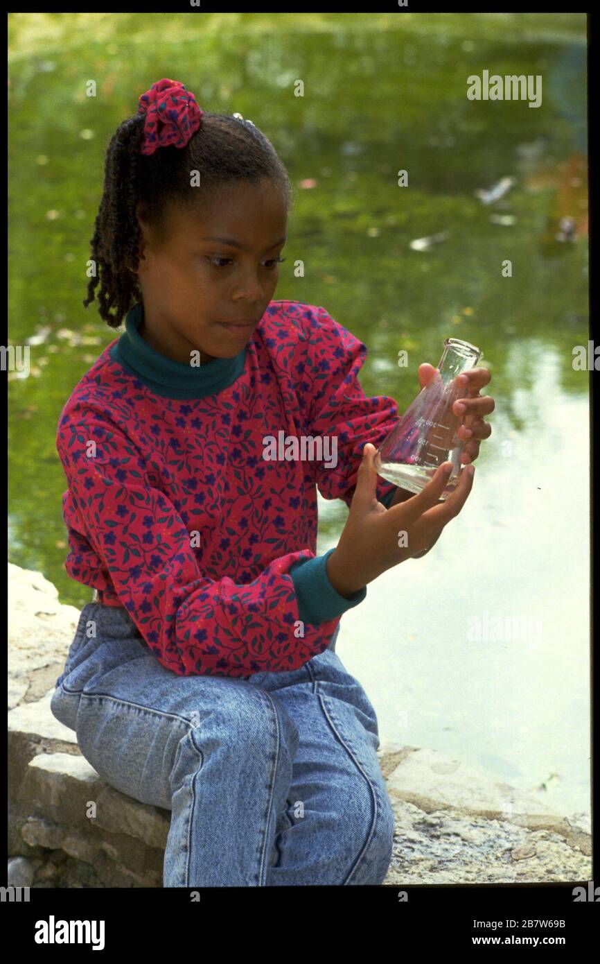 Austin Texas USA, 1991: 7th grade student explores a pond at Zilker Park as part of science experiments. MR EV-82-07  ©Bob Daemmrich Stock Photo