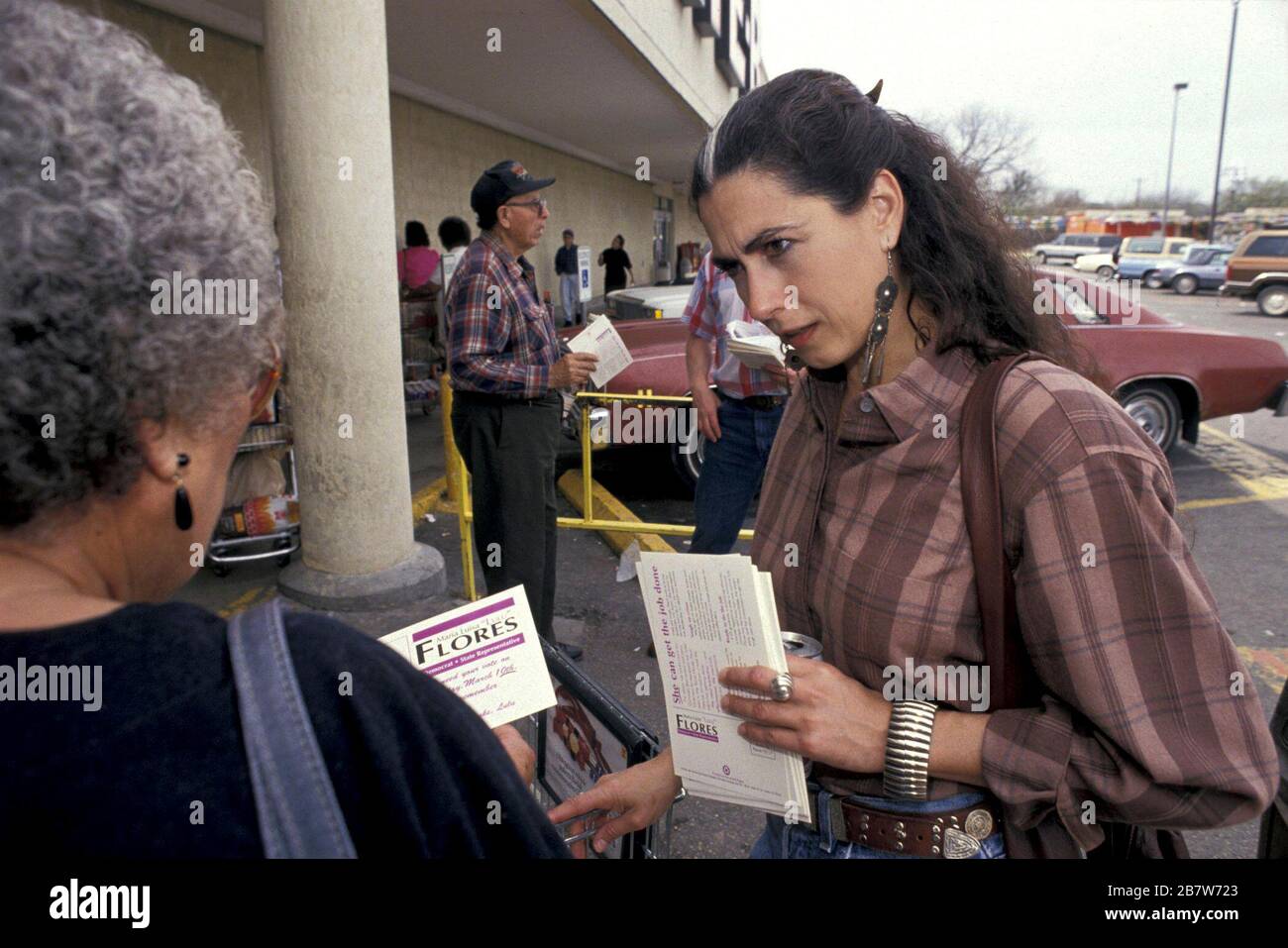 Austin Texas USA:  Hispanic woman, Lulu Flores, talks to prospective voter while campaigning in grocery store parking lot for Texas state representative. ©Bob Daemmrich Stock Photo