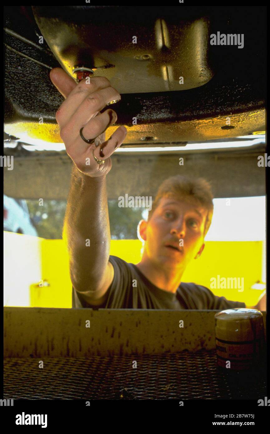 Austin Texas USA: Worker draining oil from car at quick lubricant shop. ©Bob Daemmrich Stock Photo