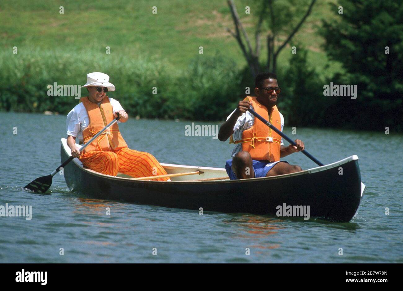 Austin, Texas USA Two people paddle canoe during canoe clinic for the disabled. ©Bob Daemmrich