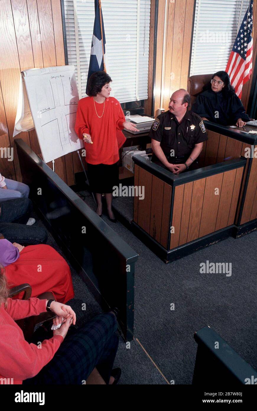 Austin Texas USA: Hispanic female judge listens as female lawyer questions county sheriff in courtroom. MR ©Bob Daemmrich Stock Photo
