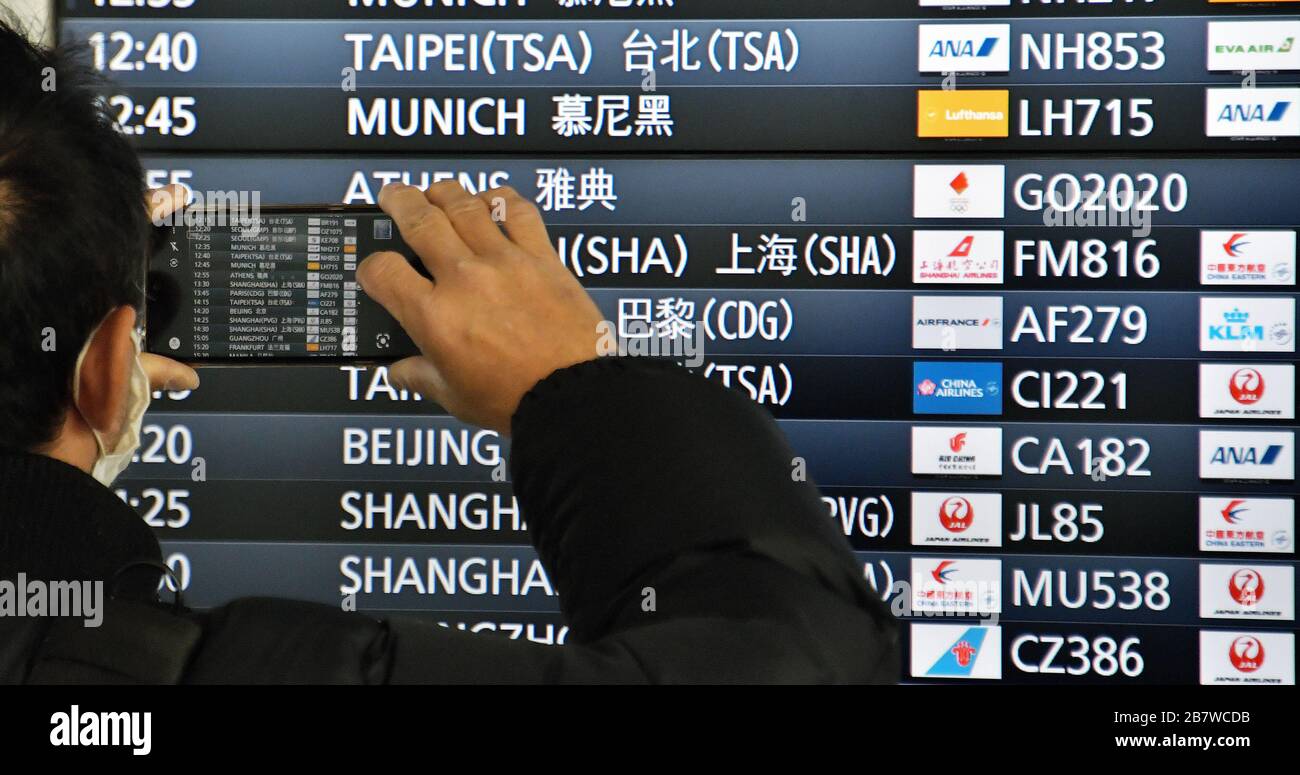 Tokyo, Japan. 18th Mar, 2020. Traveler takes photo the departure boards displayed flight 'GO2020' at Tokyo international airport in Japan on Wednesday, March 18, 2020. The Tokyo 2020 Olympic Torch Relay Special Aircraft 'Tokyo 2020 Go' transport the Olympic Flame from Greece, will land back at the Japan Air Self-Defense Force Matsushima Base in Miyagi-Prefecture, Japan on March 20. Photo by Keizo Mori/UPI Credit: UPI/Alamy Live News Stock Photo