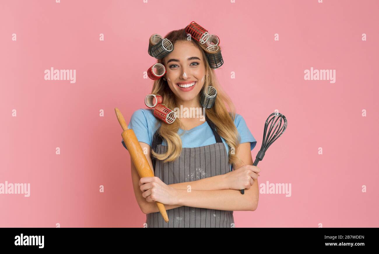 Home baking concept. Housewife with rolling pin and whisk Stock Photo