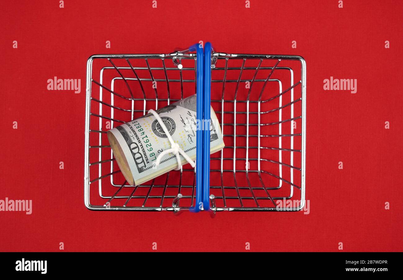 shopping basket with money, top view. bright red background, copy space