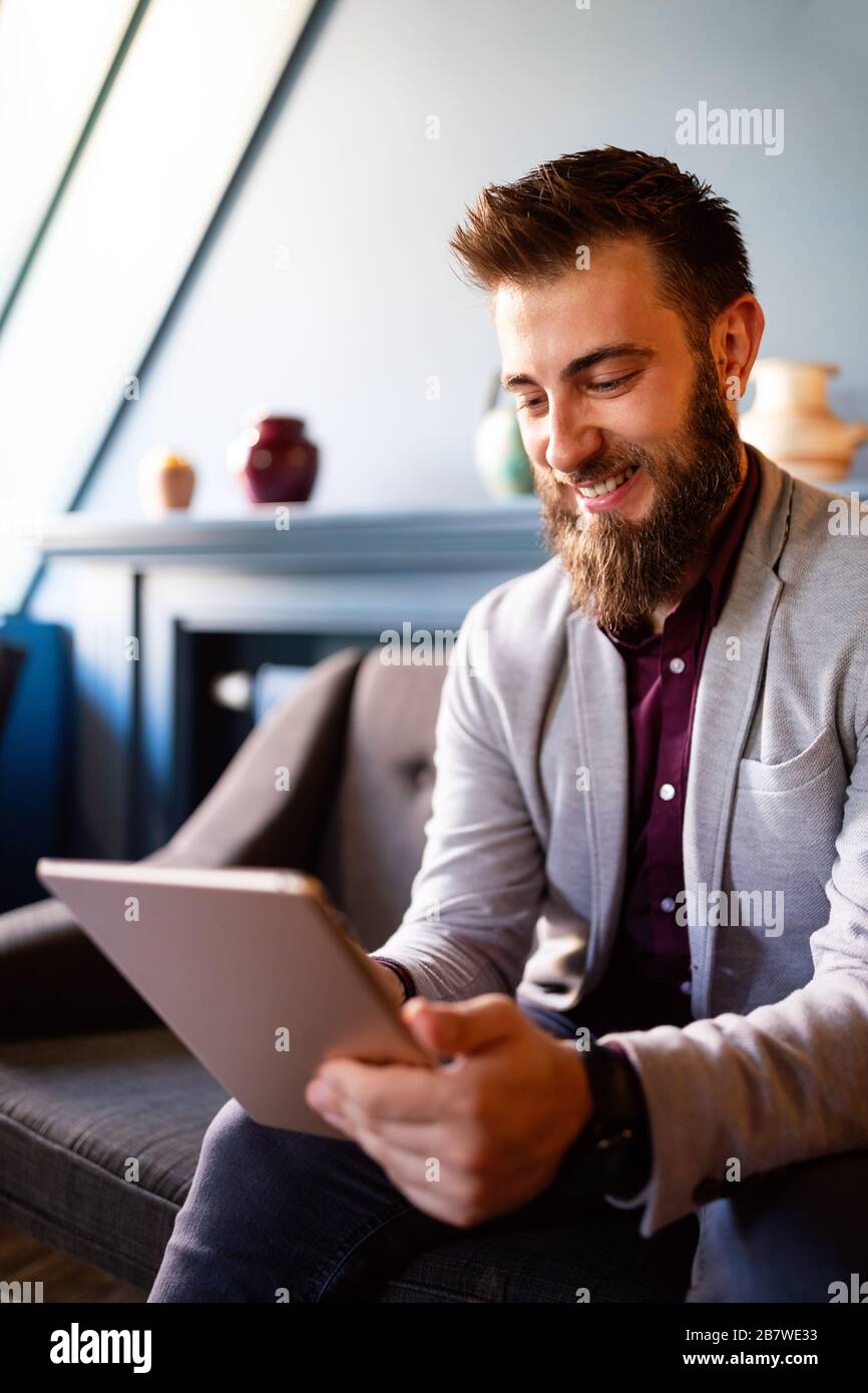 Young business man working, relaxing on the sofa with a tablet Stock Photo