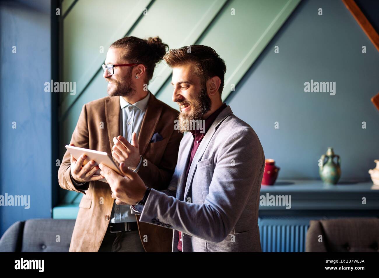 Sharing fresh ideas. Group of young business people in smart casual wear talking and smiling Stock Photo