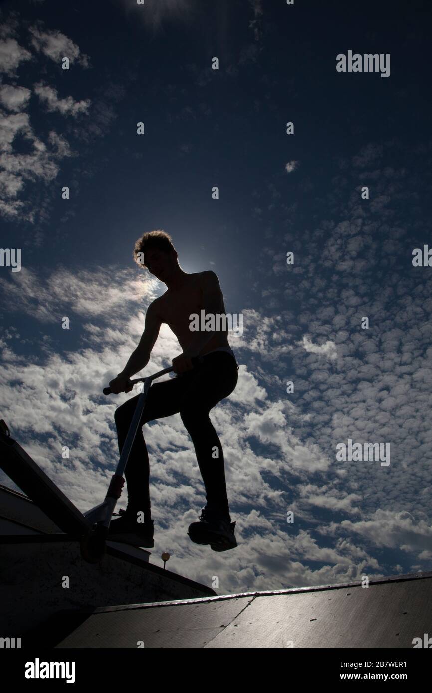 Silhouette of Man Jumping on Ramp at Skate Park Stock Photo