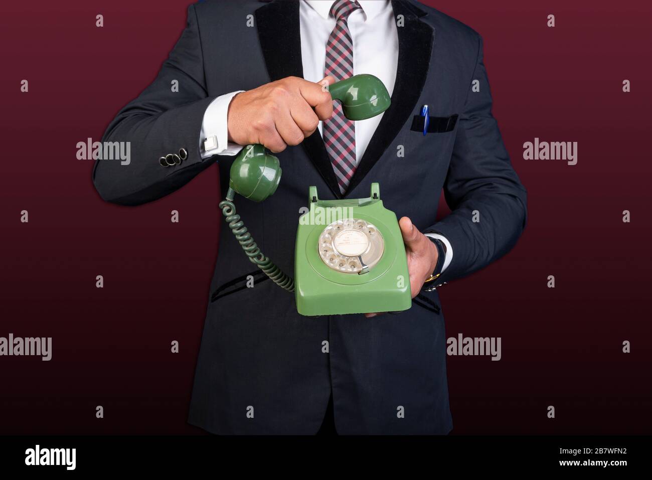 Businessman holding landline Phone in hands contact us concept Stock Photo