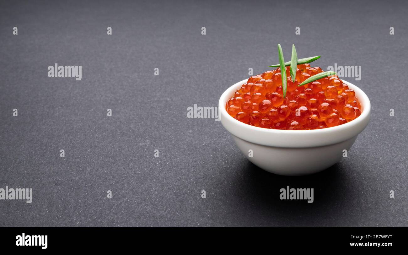 Red caviar on black stone background with copy space close-up Stock Photo
