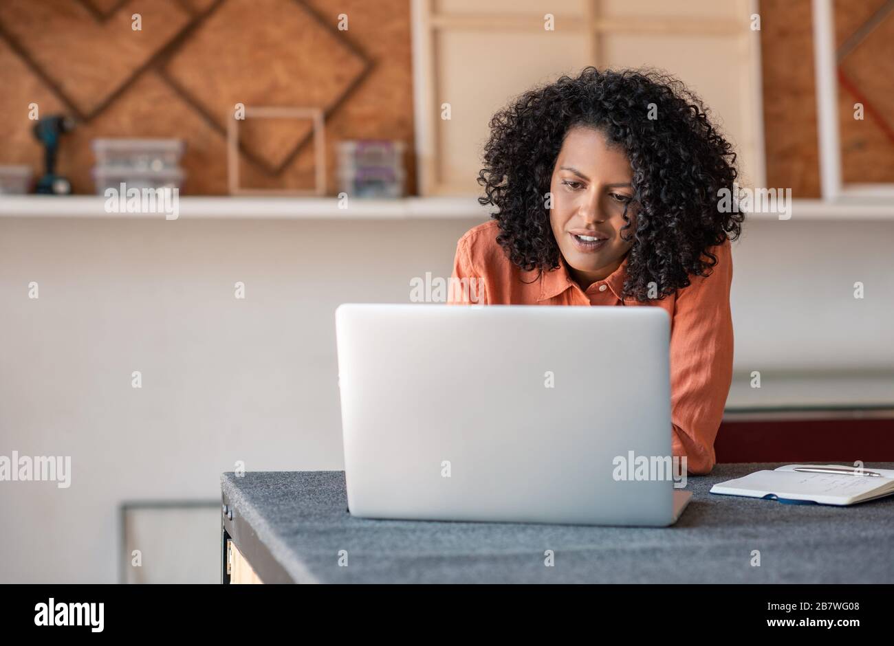 Woman using a laptop while working in her framing shop Stock Photo