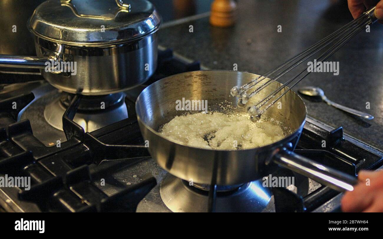 First phase of making caramel. Melting and whisking sugar in pan Stock